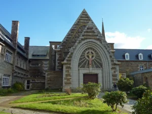 Façade néogothique de la chapelle Saint-Joseph de Lannion en granite, avec grand arc brisé et christ en croix, Côtes-d'Armor, Bretagne