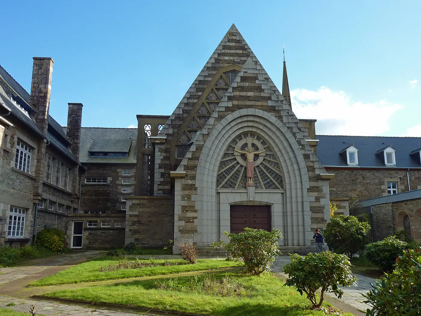 Façade néogothique de la chapelle Saint-Joseph de Lannion en granite, avec grand arc brisé et christ en croix, Côtes-d'Armor, Bretagne