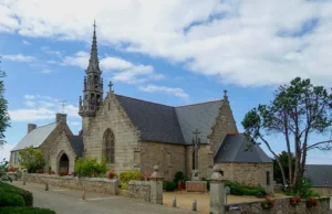 Église du bourg de Trélévern en granite avec clocher-flèche néogothique et parvis fleuri, Côtes-d'Armor, Bretagne