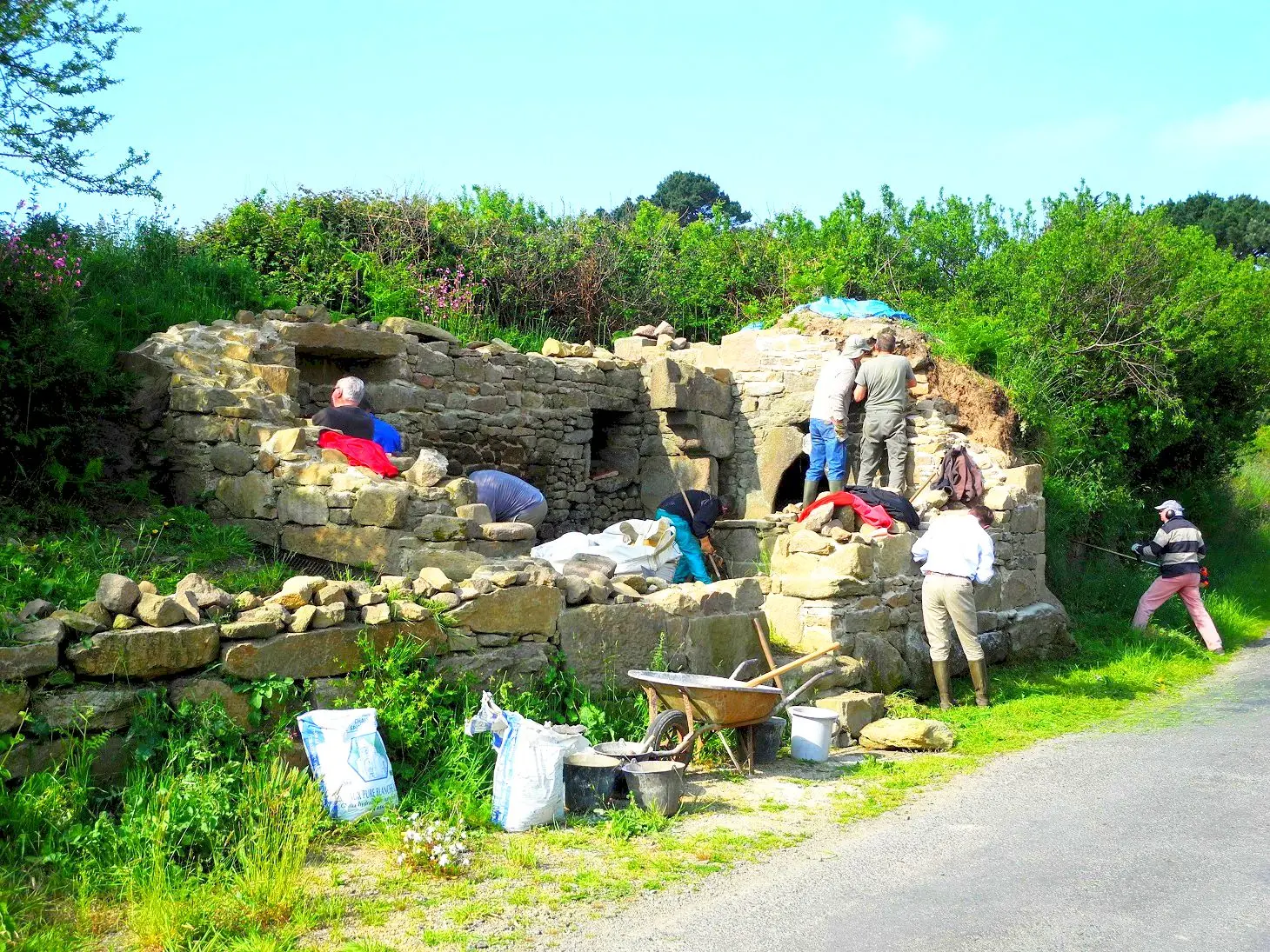 Bénévoles de l'ARSSAT participant à un chantier de restauration d'un four à pain en pierre.